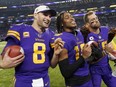 Vikings' Kirk Cousins, left, Justin Jefferson, centre, and Adam Thielen, right, eat turkey legs on the field after defeating the Patriots at U.S. Bank Stadium in Minneapolis, Thursday, Nov. 24, 2022.