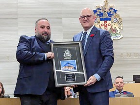 Ward 3 Coun. Rino Bortolin receives a gift of recognition from Windsor Mayor Drew Dilkens during Bortolin's final council meeting on Wednesday, Nov. 9, 2022.