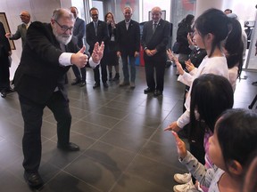 Krzysztof Stanowski, director, International Cooperation Centre of the City of Lublin, Poland plays a game with local students at a ribbon cutting ceremony for the International Children's Art Exhibition at Windsor City Hall on Friday, November 18, 2022.