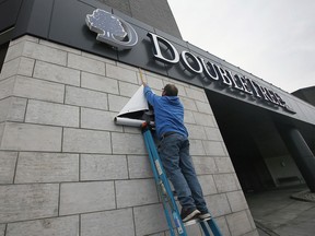 Steve Wheldon hangs a banner before the official grand opening of the new DoubleTree by Hilton Windsor Hotel and Suites on Tuesday, Nov. 29, 2022. (DAN JANISSE/Postmedia Network)
