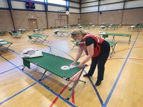 A Canadian Red Cross worker sets up cots at the John Atkinson Memorial Community Centre in Windsor on Tuesday, November 22, 2022. The emergency shelter is for residents displaced from the 1616 Ouellette Avenue apartment complex.