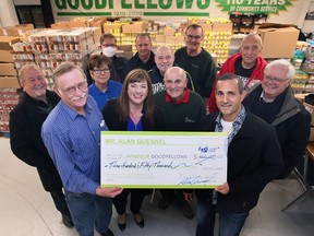Windsor Goodfellows volunteer/viral internet man Danny Curtis, left, president Jennifer Wells, 2022 Goodfellow of the Year Gilbert Barichello accept a $350,000 donation from local philanthropist Al Quesnel on Monday, November 28, 2022 as other members look on.
