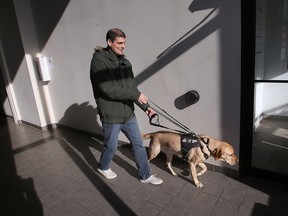 Ryan Hooey and his service dog Joe are shown at the Canadian National Institute for the Blind office in Windsor on Tuesday, November 22, 2022.