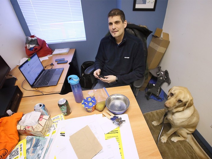  Ryan Hooey and his service dog Joe are shown at the Canadian National Institute for the Blind office in Windsor on Tuesday, November 22, 2022.