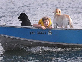 A young man and his canine friend boating at Windsor's Lakeview Marina in unseasonably warm weather on November 4, 2022.