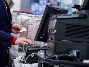 A store employee works at a cashier desk at a retail business in New Jersey on Nov. 25, 2022.