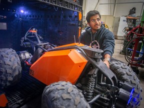 Stephen Vaidyan, a mechanical engineer at Optimotive Technologies, is pictured with an Iris 2 mk1 data collection robot, on Friday, Nov. 18, 2022.