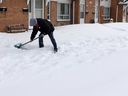 A man shovels snow in front of residences on Lauzon Road in Windsor in this 2021 file photo.