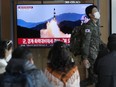 A South Korean army soldier passes by a TV screen showing a file image of North Korea's missile launch during a news program at the Seoul Railway Station in Seoul, South Korea, Wednesday, Nov. 2, 2022. South Korea says it has issued an air raid alert for residents on an island off its eastern coast after North Korea fired a few missiles toward the sea.