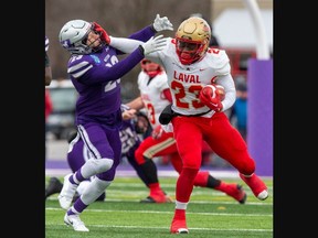 Laval Rouge et Or ball carrier Kalenga Muganda dismisses would-be Western Mustangs tackler Daniel Valente during the Mitchell Bowl at Alumni Stadium in London on Saturday November 19, 2022. Laval won the game 27-20 to earn a berth in the Vanier Cup. Derek Ruttan/The London Free Press