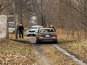 Forensics officers with Windsor police examine the burnt-out remains of a Honda Civic sedan in the area of Bloomfield Road in Windsor on Nov. 29, 2022.