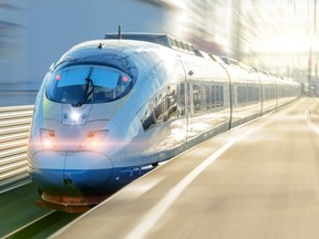 A high-speed electric passenger train departs from the platform.