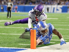 Justin Jackson of the Detroit Lions runs the ball for a touchdown against Cameron Dantzler Sr. of the Minnesota Vikings during the fourth quarter at Ford Field on December 11, 2022 in Detroit, Michigan.