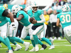 Tua Tagovailoa of the Miami Dolphins prepares to hand off the ball during the first quarter of the game against the Green Bay Packers at Hard Rock Stadium on December 25, 2022 in Miami Gardens, Florida.
