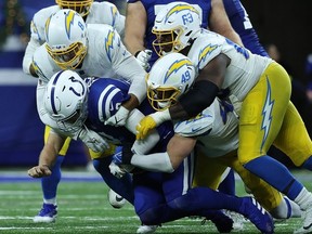 Nick Foles of the Indianapolis Colts is sacked by Drue Tranquill of the Los Angeles Chargers at Lucas Oil Stadium on December 26, 2022 in Indianapolis, Indiana.