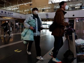 Travellers walk with their luggage at Beijing Capital International Airport, amid the COVID-19 outbreak in Beijing, China, Tuesday, Dec. 27, 2022.