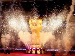 Pyrotechnics explode around a giant FIFA World Cup trophy prior to the semifinal match between France and Morocco at Al Bayt Stadium in Al Khor Qatar, Wednesday, Dec. 14, 2022.