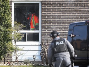 A police officer attempts to contact a man inside his home on Block 1300 of Copperfield Place in the Little River Acres area of ​​Windsor on December 1, 2022.