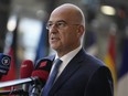 Greece's Foreign Minister Nikos Dendias speaks with the media as he arrives for a meeting of EU foreign ministers at the European Council building in Brussels, Monday, December 12, 2022.