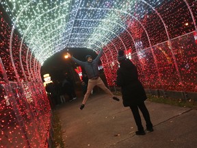 Visitors to Bright Lights Windsor at Jackson Park take photos with a luminous display on Friday, Dec. 2, 2022.