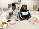 Brother and sister Kelvin and Shannah Antwi, of Cincinnati, are among the 60 travellers stranded in Friday's massive winter storm that found shelter at Chatham Christian School. Here they enjoy breakfast on Saturday. PHOTO Ellwood Shreve/Chatham Daily New