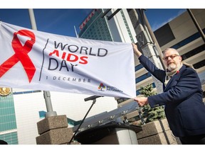 Michael Brennan, executive director at Pozitive Pathways, holds the World AIDS Day flag during a flag raising ceremony at Charles Clark Square for World AIDS Day on Thursday, Dec. 1, 2022.