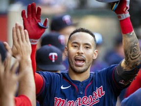 Minnesota Twins' Carlos Correa, right, is congratulated after hitting a solo home run against the Los Angeles Angels during the first inning of a baseball game in Anaheim, Calif., Saturday, Aug. 13, 2022.