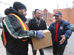 Canadian Italian Business and Professional Association of Windsor members Carlo Cafueri, left, and Joe Balsamo hand out a Christmas food package to a recipient at the downtown Windsor Goodfellows office on Saturday, December 17, 2022.