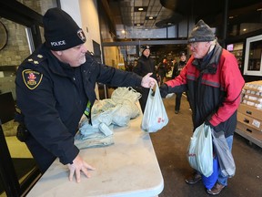 Windsor Police Deputy Chief Jason Crowley hands out a turkey to Allan MacDonald, 69, on Friday, December 23, 2022 during the 18th annual Mikhail Holdings turkey giveaway event.