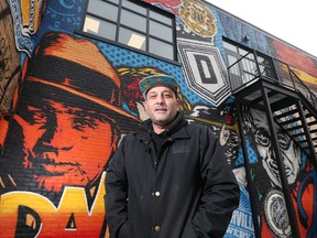 Artist Daniel Bombardier poses next to his latest mural in Walkerville on Wednesday, December 21, 2022.