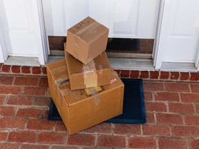 Packages dropped off at the front door of a residence are shown in this stock image.