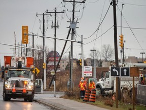Hydro crews work to repair a leaning hydro pole on Manning Road, north of Amy Croft Drive, on Thursday, Dec. 15, 2022.