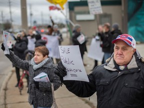 Dozens of protesters rally for better healthcare at the intersection of Walker Road and Tecumseh Road East, on Monday, Dec. 12, 2022.