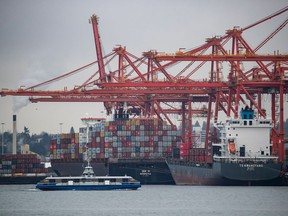 Gantry cranes tower above container ships being unloaded and loaded at port, in Vancouver, on Thursday, February 10, 2022.Statistics Canada says the country's merchandise trade surplus grew to $1.2 billion in October as exports climbed faster than imports.THE CANADIAN PRESS/Darryl Dyck