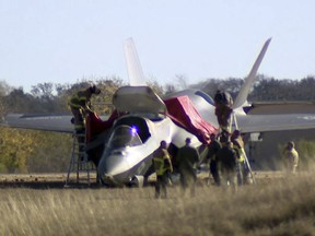 This image taken from video provided by KDFW, shows emergency personnel at the scene after a fighter jet crash landed at Naval Air Station Joint Reserve Base in Fort Worth, Texas, Thursday, Dec. 15, 2022.