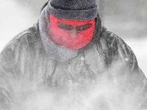 A Windsor man bundles up while using a snow blower in this December 2013 file photo.