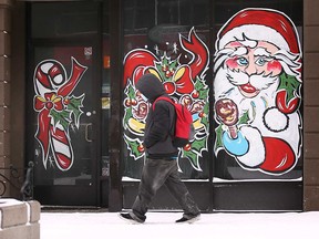 A pedestrian on Ouellette Avenue walks past a Christmas display on Dec. 25, 2020.