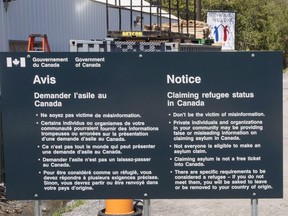 A sign warning asylum seekers is seen at the Canada/U.S. border at Roxham Road on May 9, 2018 in Champlain, N.Y.