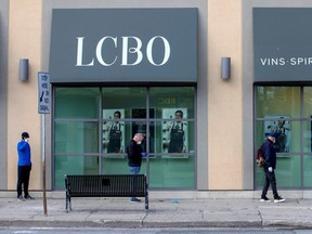 People wait outside of the LCBO to purchase alcohol in the early days of COVID-19 restrictions, in Toronto, April 9, 2020.