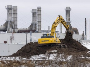 A large excavator moves dirt at the site of a 400,000-square-foot expansion at the Cami Assembly plant in Ingersoll that sources say will allow the automaker to assemble batteries for the BrightDrop fully electric cargo delivery vans being made at the plant. Photograph taken on Friday, Jan. 13, 2023. (Mike Hensen/The London Free Press)