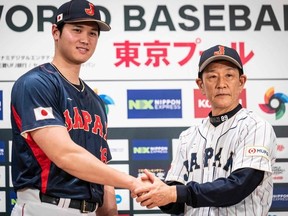 Shohei Ohtani (L) of the Los Angeles Angels and manager of Japan's national baseball team Hideki Kuriyama shake hands during a press conference ahead of the 2023 World Baseball Classic tournament in Tokyo on January 6, 2023.
