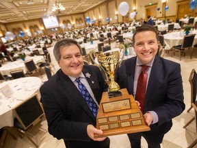 Quizmaster, Jack Ramieri, left, and Eugene van Wyk, manager of Fund Development and Community  Engagement for the Alzheimer Society of Windsor and Essex County, hold the Battle of the Brains trophy before the start of the annual trivia fundraiser at the Ciociaro Club, on Friday, Jan. 20, 2023.