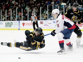 Windsor Spitfires' ce tre Noah Morneau (11) trips Sarnia Sting's Tyson Doucette (25) in the first period of Friday's game at Progressive Auto Sales Arena. Mark Malone/Chatham Daily News/Postmedia Network