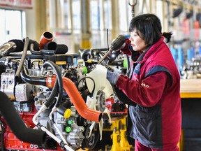 An employee works on a vehicle assembly line in China.