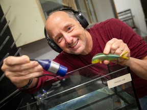 Dennis Higgs, professor of integrated biology at the University of Windsor, uses a prop fish with a hydro phone, to illustrate how he's been studying communication between fish, while at his lab on Friday, Jan. 13, 2023.