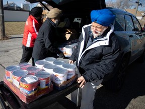 Jatinder Rai, president of the Windsor Sports and Culture Centre, along with other members of the club, unload a large food donation at Street Help, on Saturday, Jan. 14, 2023.