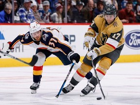 Vegas Golden Knights defenseman Ben Hutton controls the puck under pressure from Colorado Avalanche left wing J.T. Compher in the third period at Ball Arena.