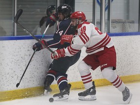 LaSalle Vipers' defenceman Carson Woodall, left, is hit along the board by Leamington Flyers' captain Gabe Piccolo.