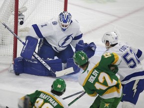 Tampa Bay Lightning goaltender Brian Elliott (1) stops a shot by Minnesota Wild left wing Matt Boldy (12) with defense from Tampa Bay Lightning defenseman Cal Foote in the first period during an NHL hockey game, Wednesday, Jan. 4, 2023, in St. Paul, Minn.