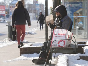 Art Varley panhandles for money at the corner of Ouellette Avenue and Wyandotte Street in downtown Windsor on Tuesday, January 31, 2023.